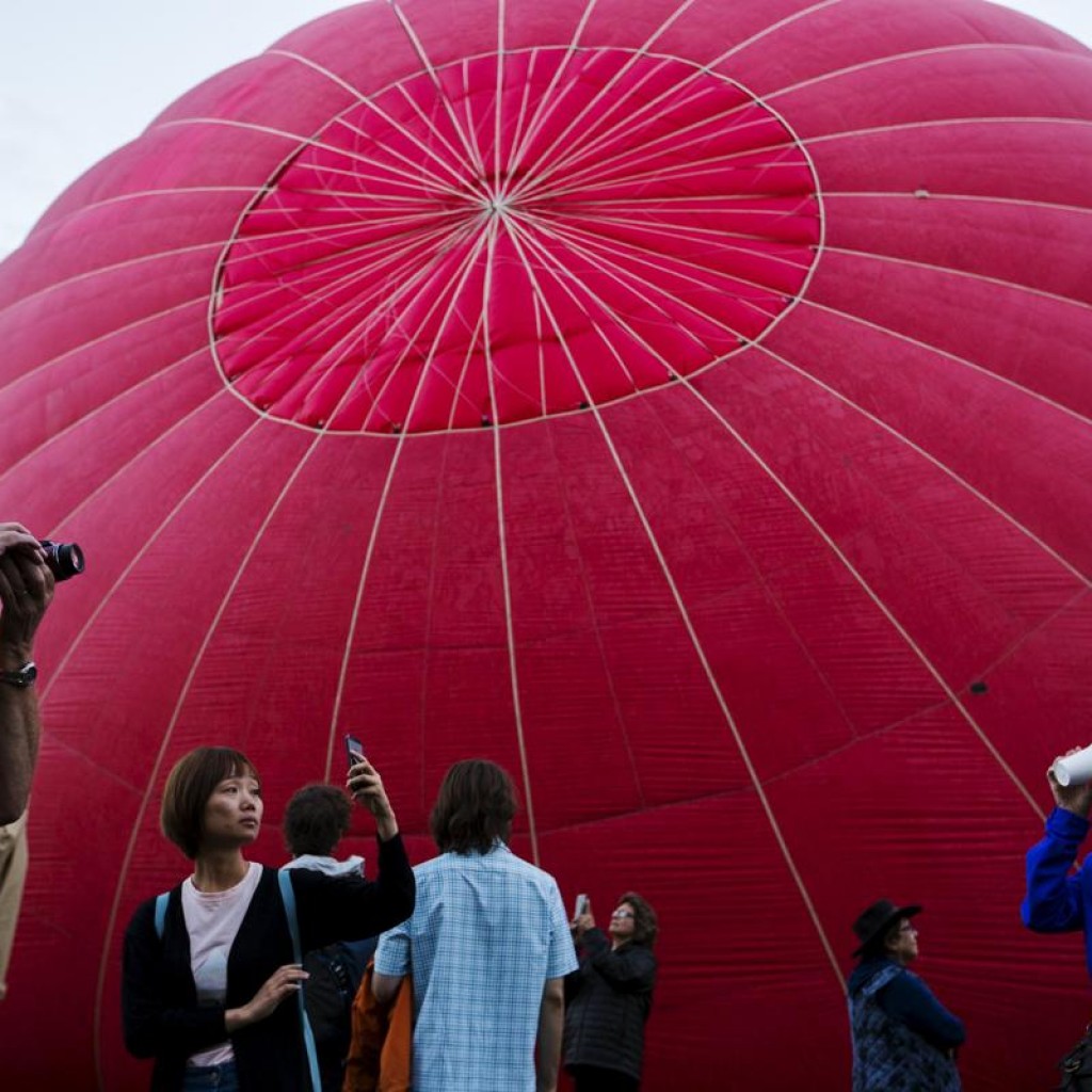 Khán giả đến xem và chụp ảnh khi hàng trăm chiếc khinh khí cầu được thả lên không trong trong ngày đầu tiền của lễ hội Albuquerque International Balloon Fiesta, ở New Mexico, 03/10/2015.