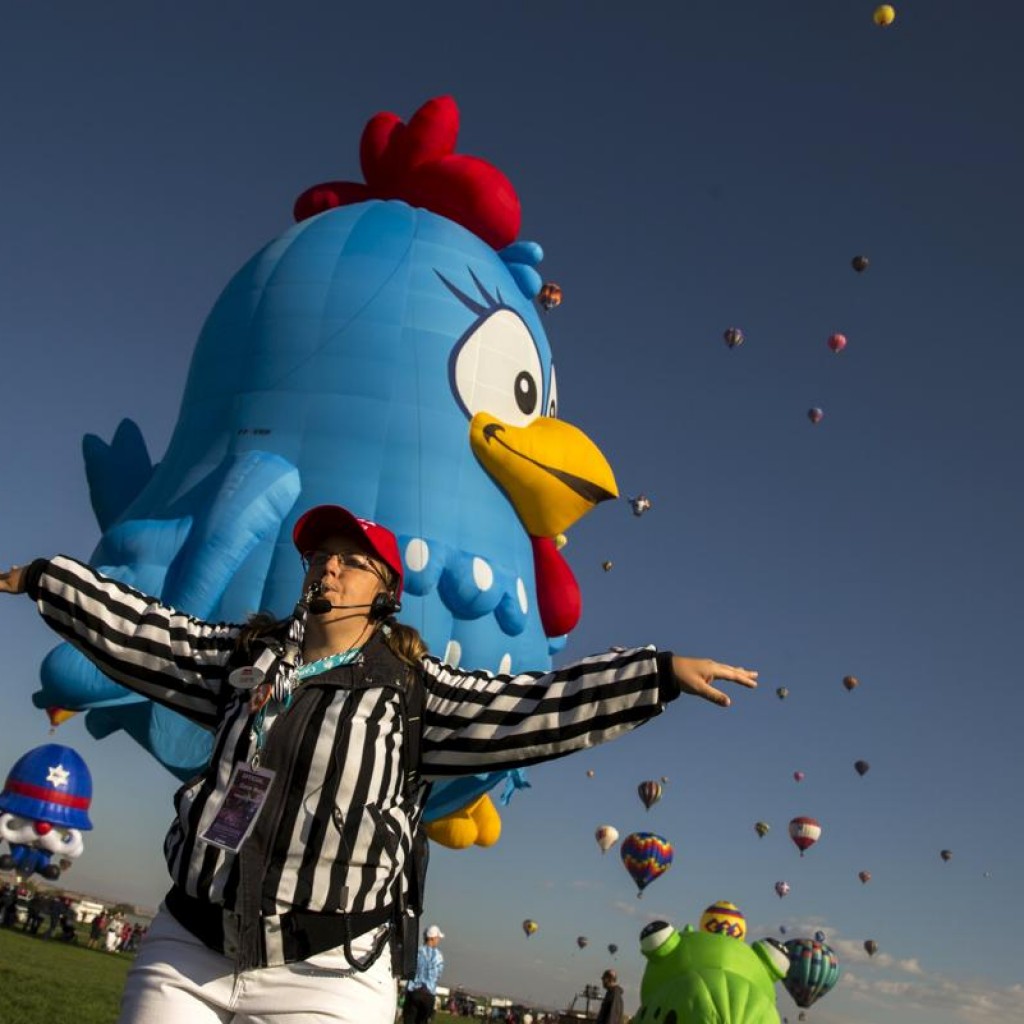 Một người giám sát việc thả khinh khí cầu yêu cầu khán giả tránh đường khi một khinh khí cầu lớn chuẩn bị tiếp đất trong ngày đầu tiên của lễ hội Albuquerque International Balloon Fiesta 2015.