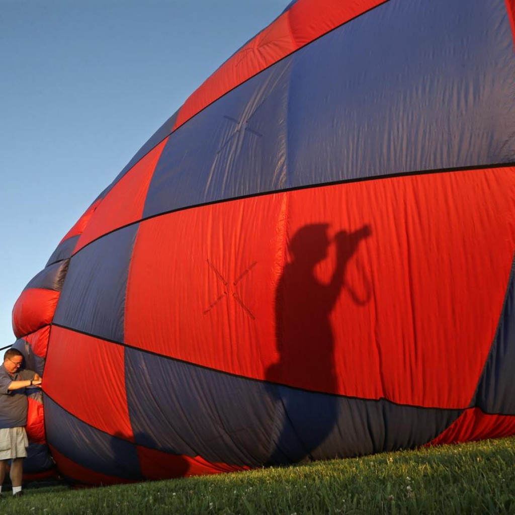 Bóng của một người chụp ảnh in lên trên chiếc khinh khí cầu tại lễ hội QuickChek New Jersey, ở sân bay Solberg, Readington, New Jersey, 24/07/2015.