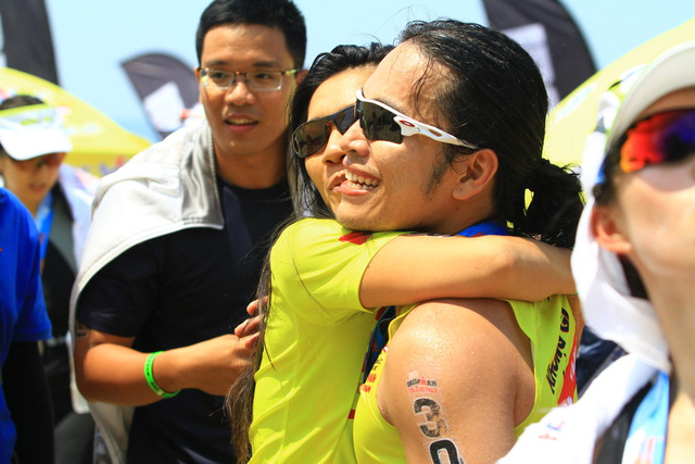 Mặc dù rất mệt mỏi sau hai phần thi, Ngô Quang Thảo (áo đen) và Hoa Nguyễn vẫn đợi ở đích chặng bán marathon để đón và chia vui với Hoàng Lê Giang